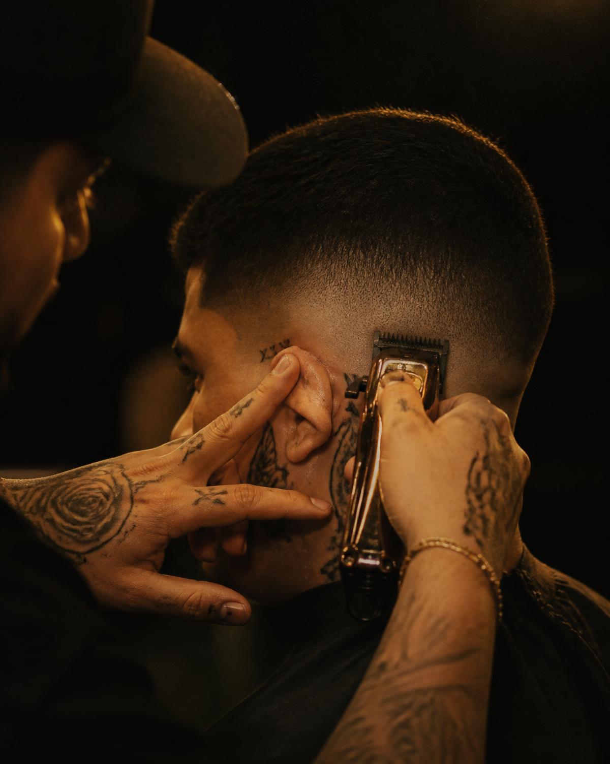 Barber blending a skin fade with clippers